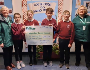 Primary 7 children present a cheque for £676.34 to Macmillan Cancer Support